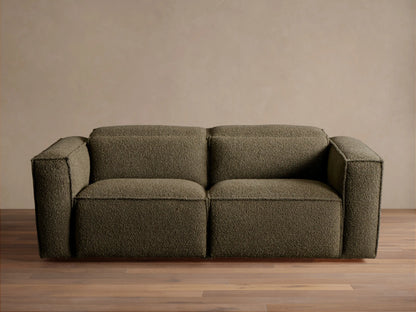 Coburn Two-Piece Motion Sofa in dark olive green textured fabric, a modern two-seater with square arms, on a wood floor.