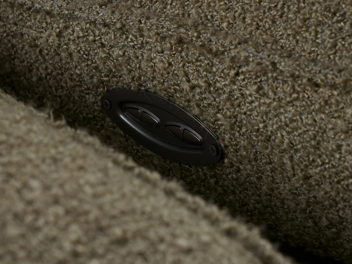 Close-up of Coburn Two-Piece Motion Sofa armrest, seat, and reclined footrest in textured olive green bouclé-like fabric.