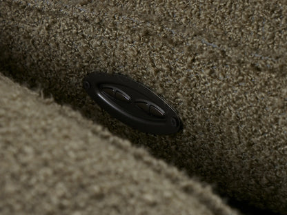 Close-up of Coburn Two-Piece Motion Sofa armrest, seat, and reclined footrest in textured olive green bouclé-like fabric.