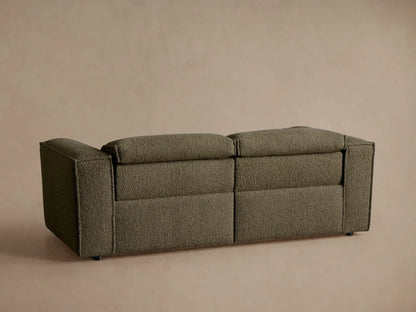 Coburn Two-Piece Motion Sofa close-up: textured olive Crypton fabric with a dark brown oval two-button recliner control.