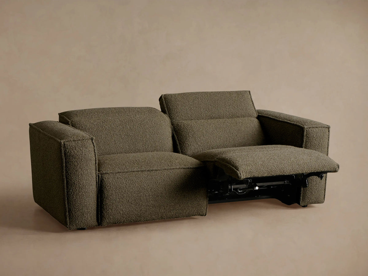 Coburn Two-Piece Motion Sofa: dark green textured fabric. Left seat reclined, right upright, on a neutral background.