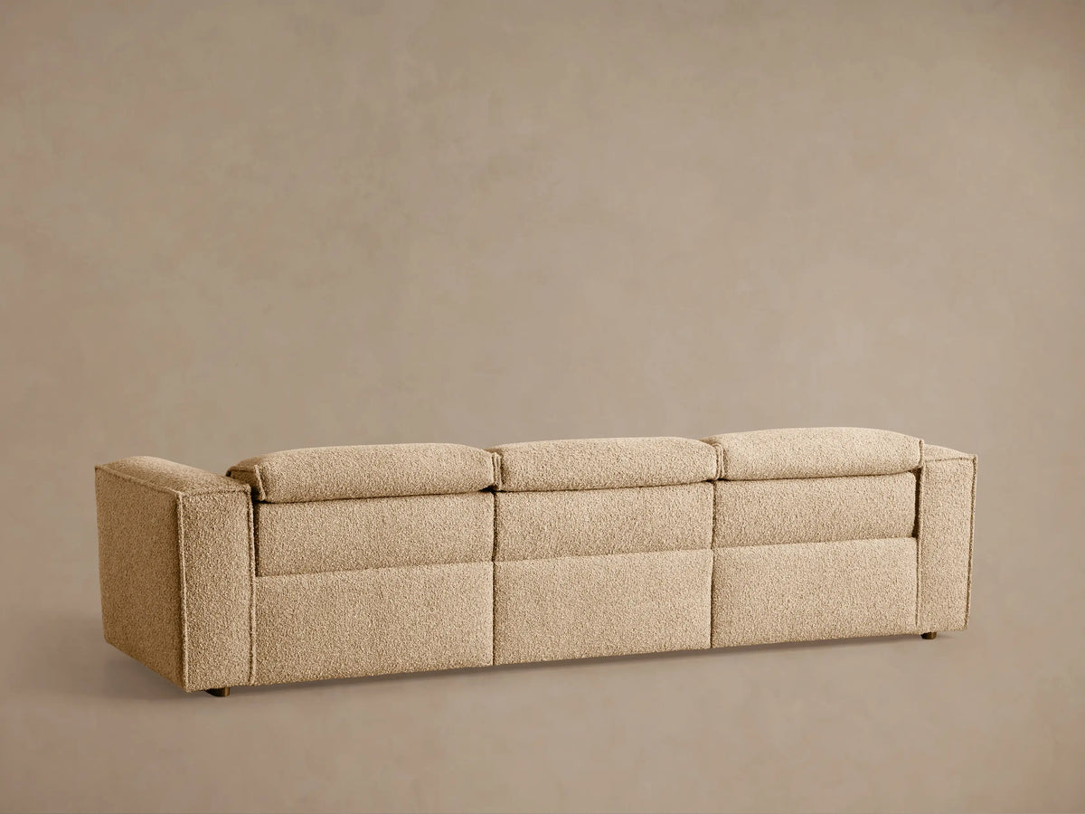Close-up of Coburn Motion Sofa's textured tan fabric with an embedded black oval two-button reclining control panel.