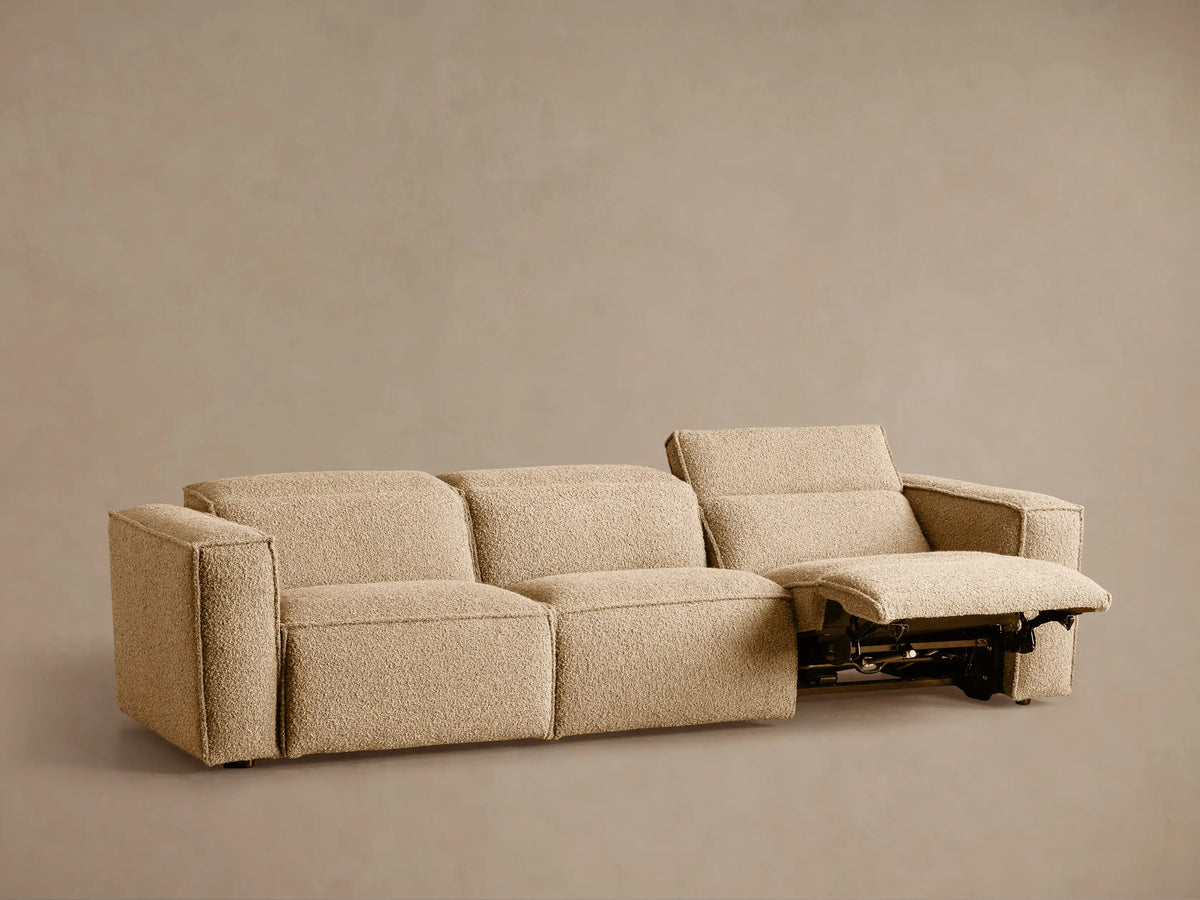 Coburn Three-Piece Motion Sofa, light beige textured fabric. Left section reclined with elevated footrest & tilted backrest.