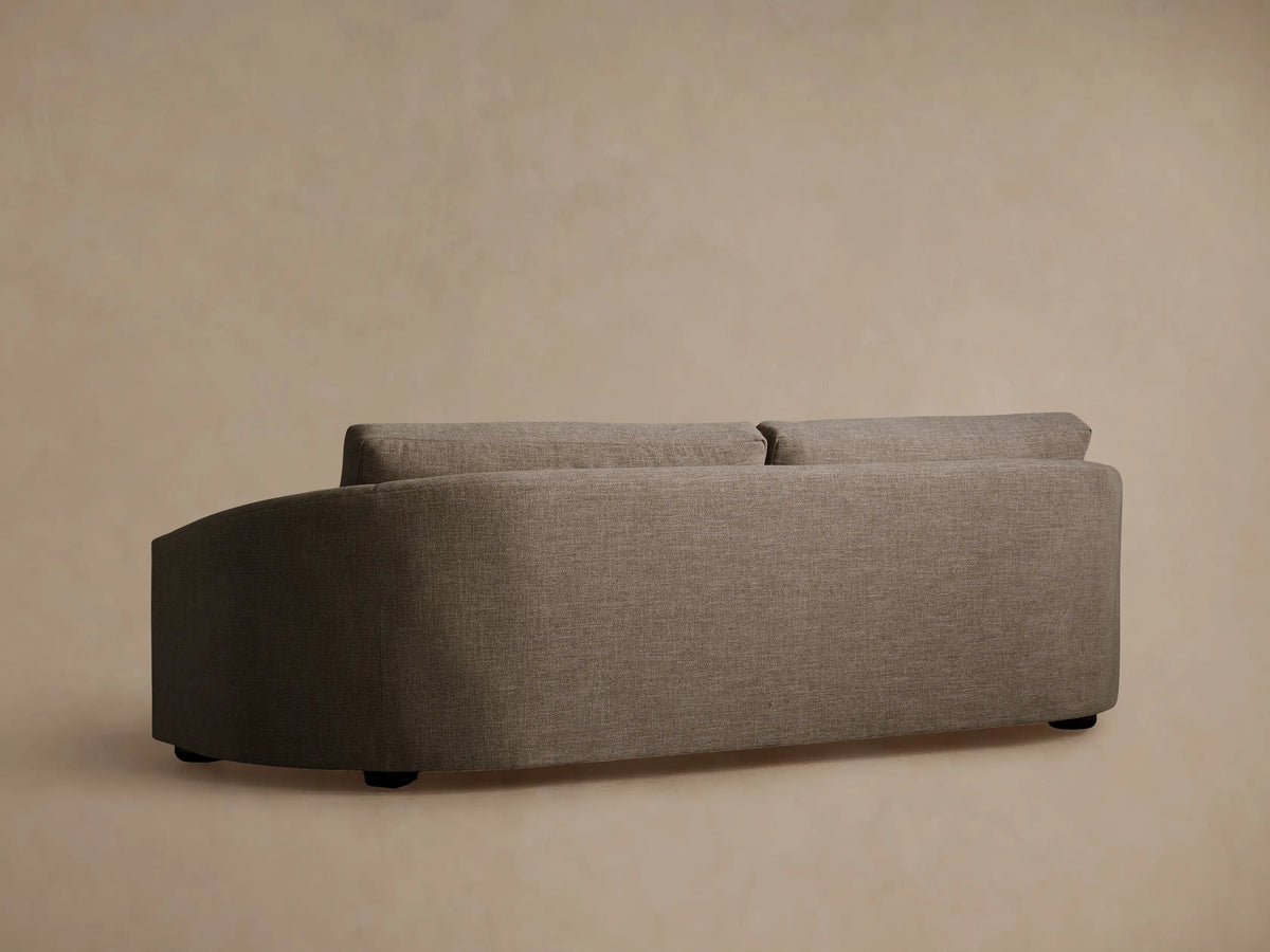 Close-up of Avon Sofa in light brown textured fabric, showing a back cushion and a curved armrest.