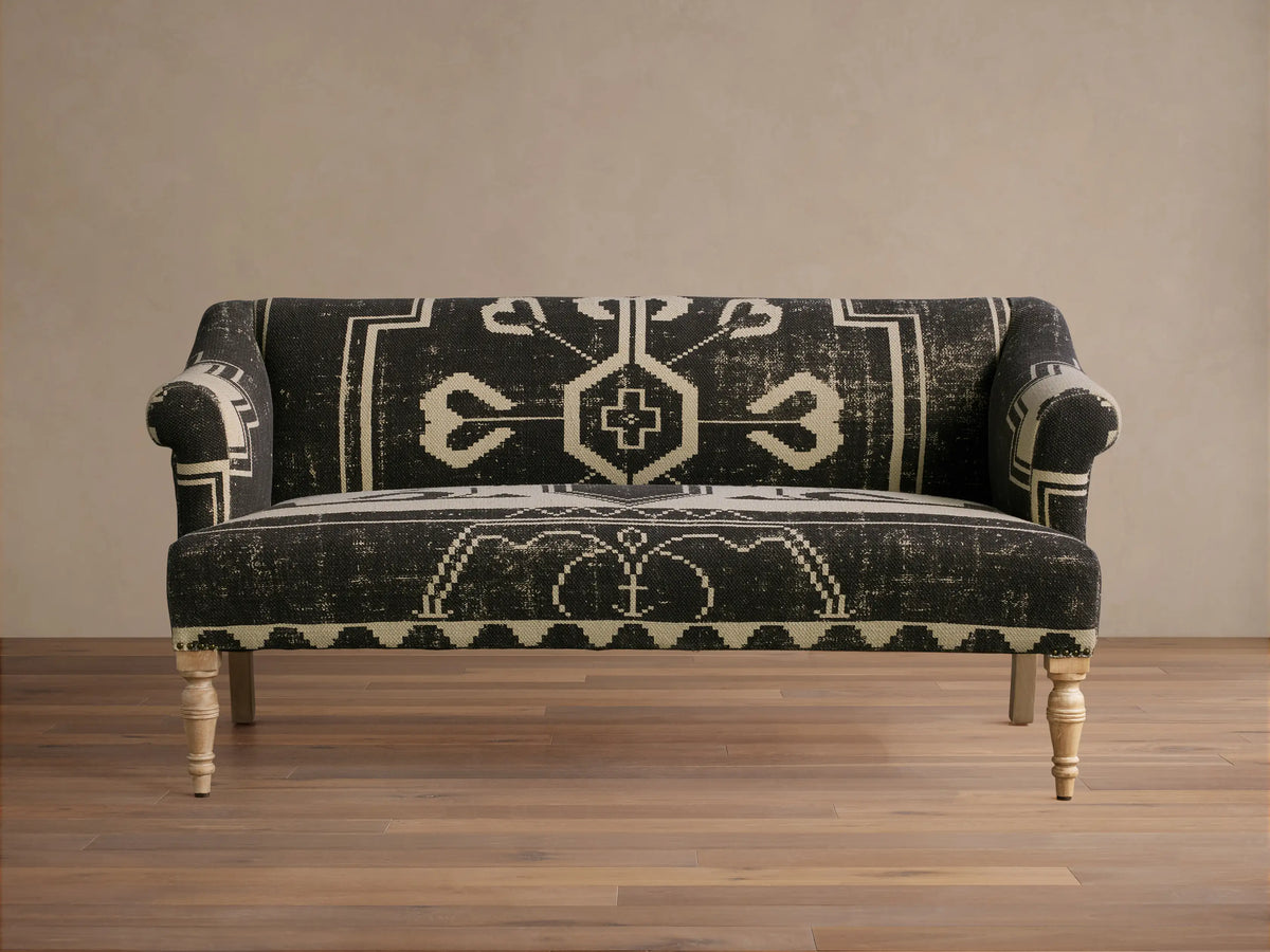 Anya Settee, black and cream fabric with distressed geometric tribal pattern, rolled arms, light turned wood legs.