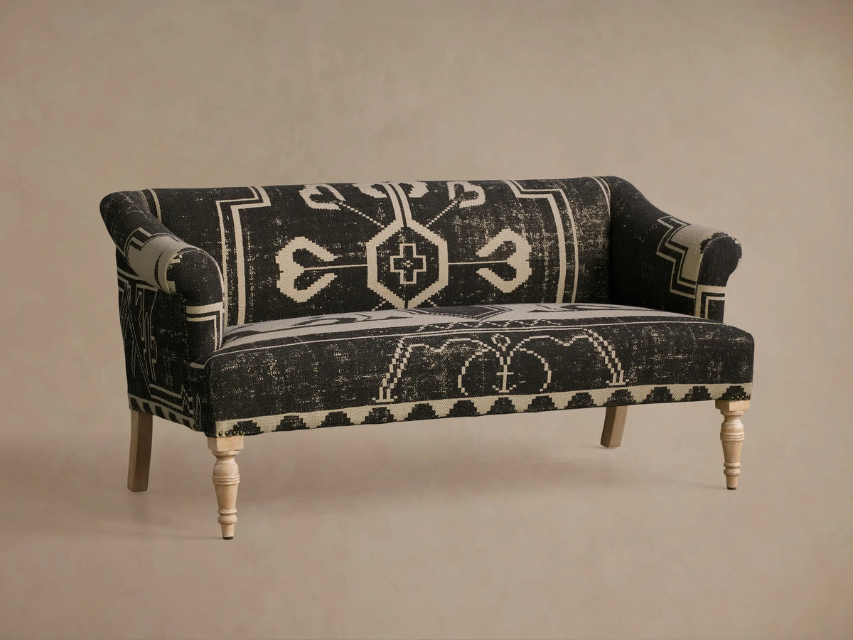 Anya Settee, black and cream fabric with distressed geometric tribal pattern, rolled arms, light turned wood legs.