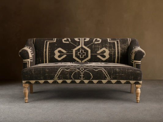 Anya Settee, black and cream fabric with distressed geometric tribal pattern, rolled arms, light turned wood legs.