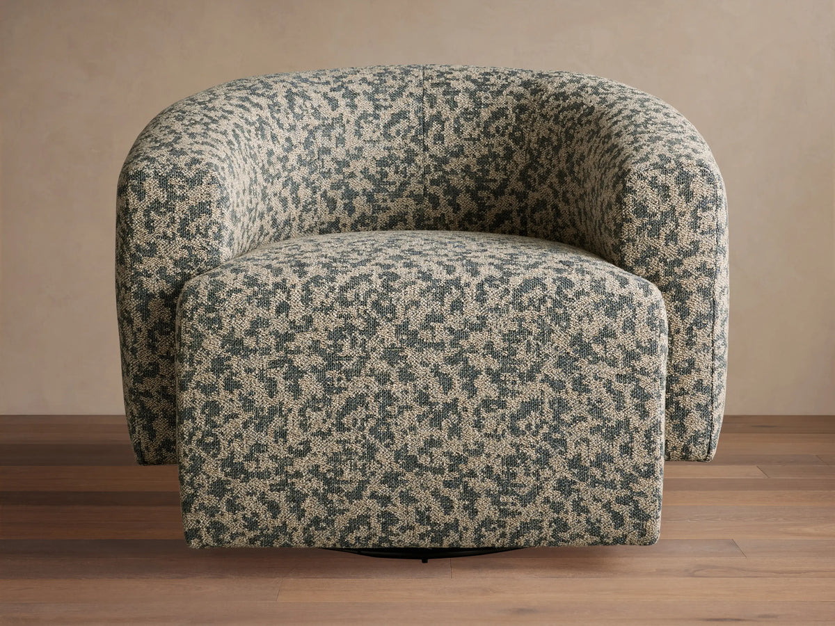 Two mustard velvet Hamlin Swivel Chairs, rounded barrel shape, in a bright living room by large windows.