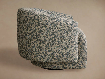 Round Hamlin Swivel Chair in mottled beige & blue-green fabric, seen side-rear with black swivel base.