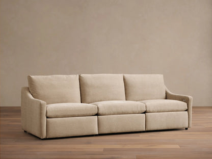 Front view of a light beige Kipton Slope Arm Three-Piece Motion Modular Sofa with three cushions and gentle slope arms.