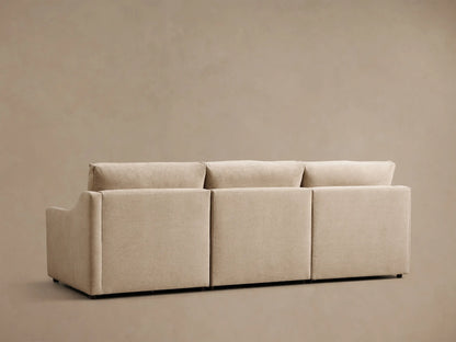 Rear and left side view of a beige Kipton Slope Arm Three-Piece Motion Modular Sofa, featuring three distinct back cushions.
