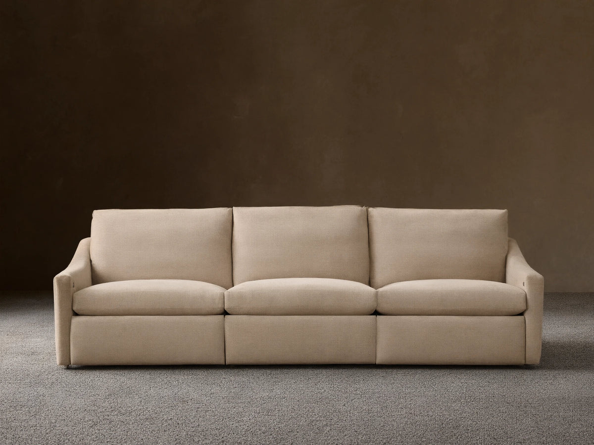 Front view of the beige Kipton Slope Arm Three-Piece Motion Modular Sofa with three cushions and three motion bases.