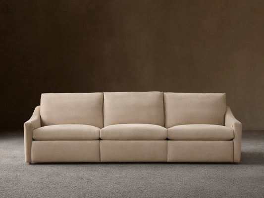 Front view of the beige Kipton Slope Arm Three-Piece Motion Modular Sofa with three cushions and three motion bases.
