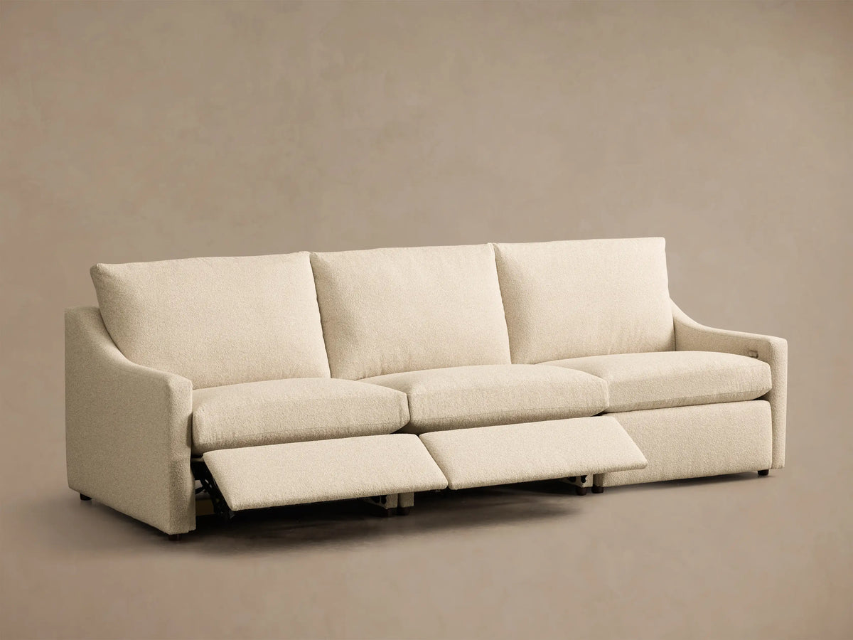Front view of the cream Kipton Slope Arm Three-Piece Motion Modular Sofa, with two of the three footrests extended.