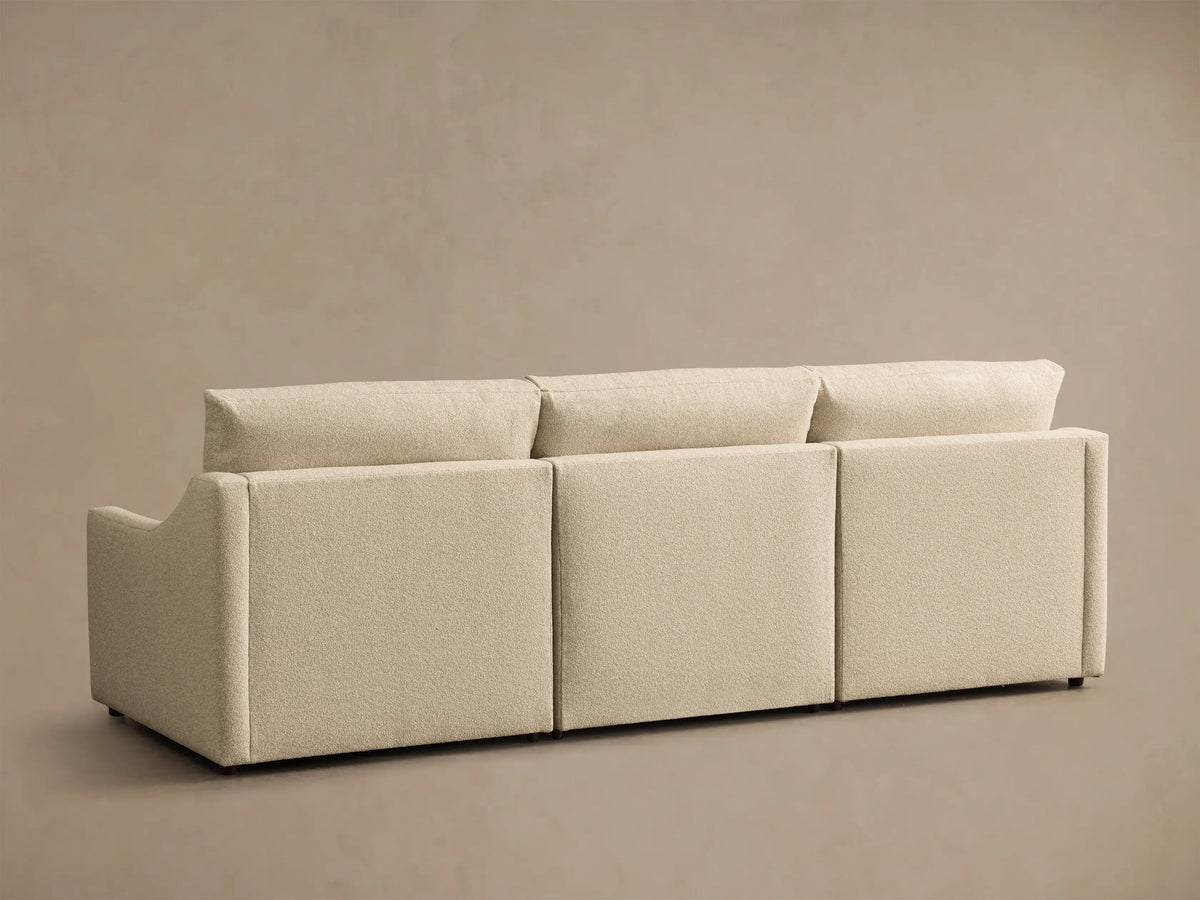 Rear view of the beige Kipton Slope Arm Three-Piece Motion Modular Sofa, showing its three modular sections and textured fabric.