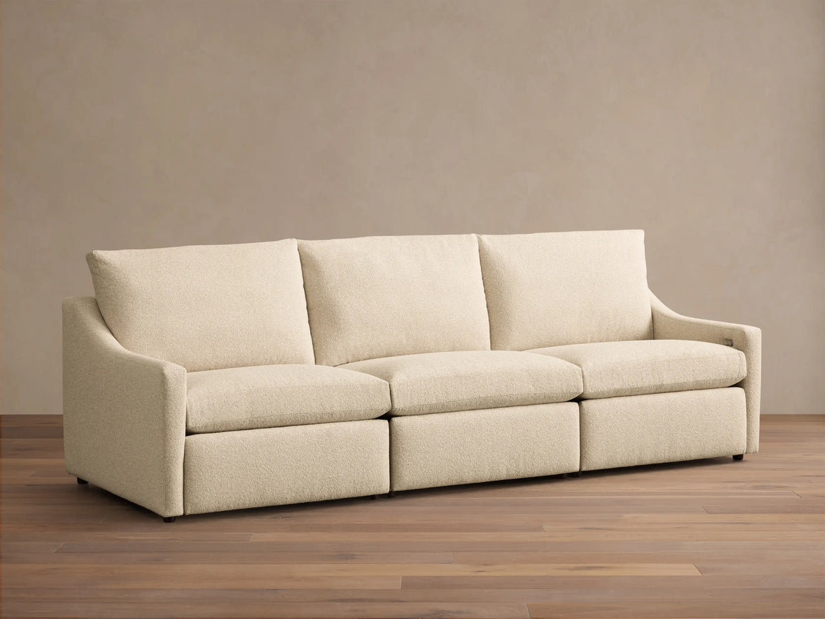 Front view of the cream Kipton Slope Arm Three-Piece Motion Modular Sofa, featuring three modular sections with loose cushions and slope arms.