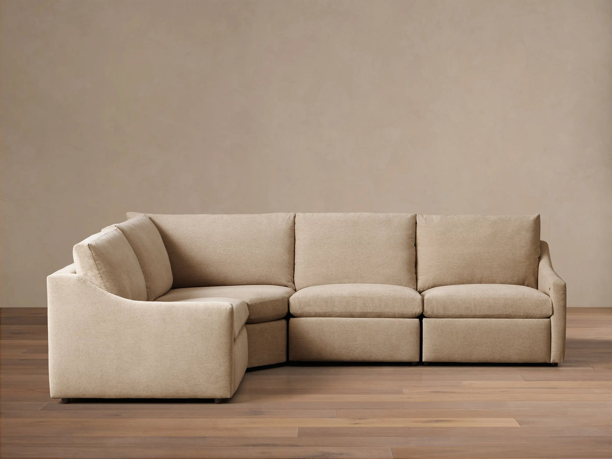 Front view of the beige Kipton Slope Arm Four-Piece Motion Sectional, arranged in an L-shape with a sloped left arm.