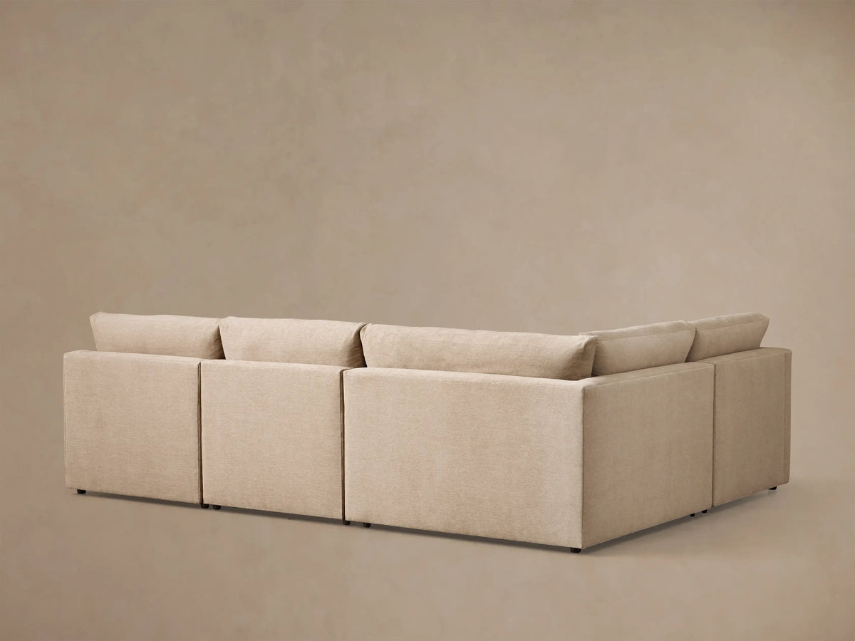 Close-up view of the beige Kipton Slope Arm Four-Piece Motion Sectional, with its footrest extended and motion control buttons.