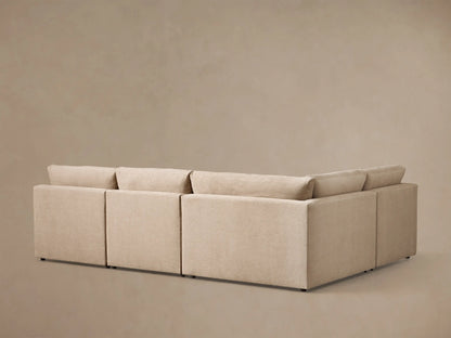 Close-up view of the beige Kipton Slope Arm Four-Piece Motion Sectional, with its footrest extended and motion control buttons.