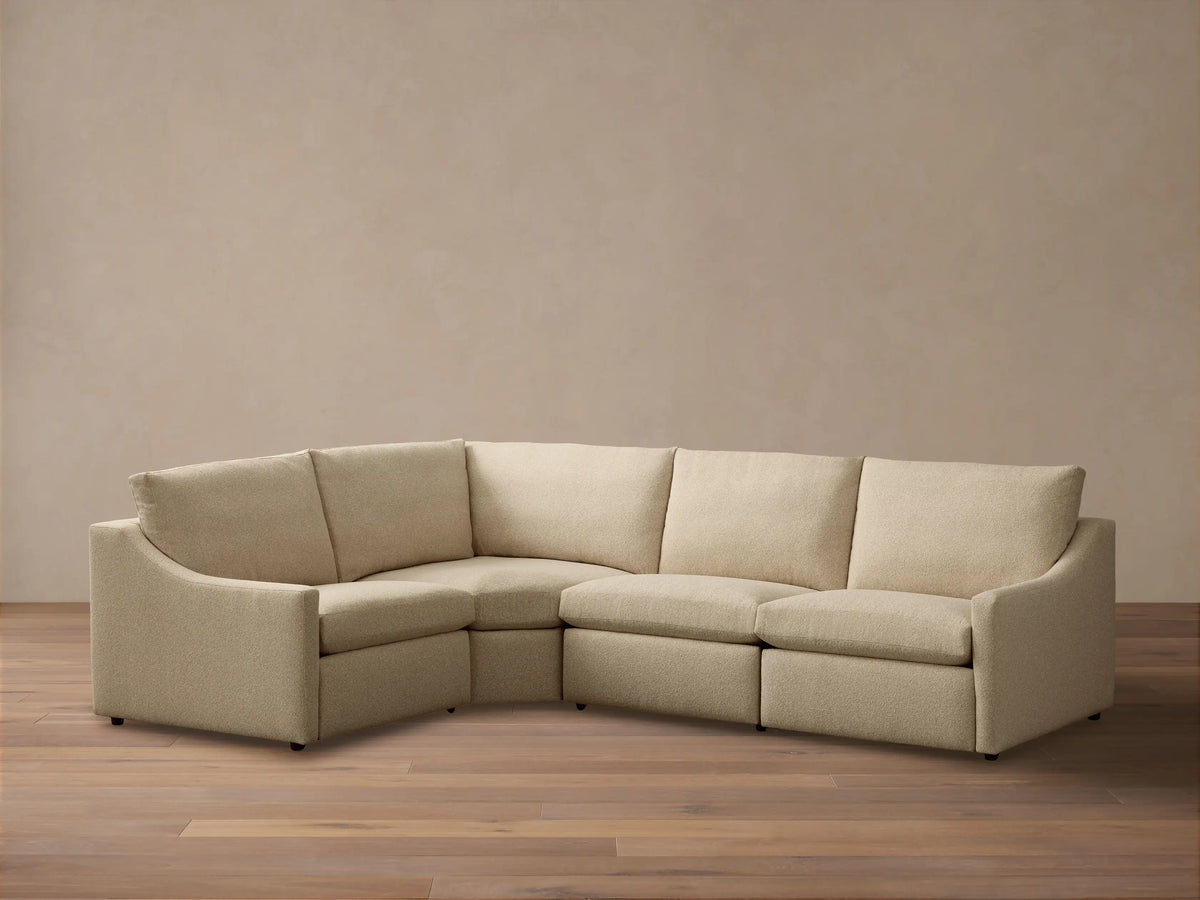 Front view of the light beige Kipton Slope Arm Four-Piece Motion Sectional with slope arms and an L-shaped configuration.