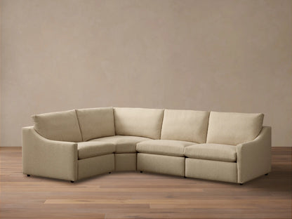 Front view of the light beige Kipton Slope Arm Four-Piece Motion Sectional with slope arms and an L-shaped configuration.