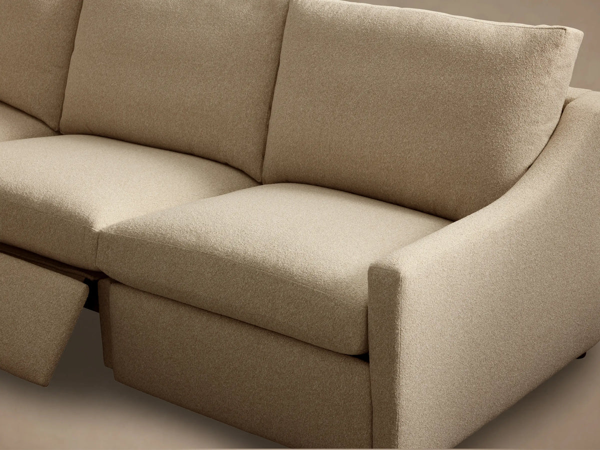 Close-up of the light beige textured fabric and bronze two-button motion control on the Kipton Slope Arm Four-Piece Motion Sectional.