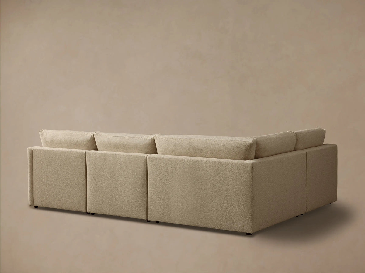 Close-up of a beige Kipton Slope Arm Four-Piece Motion Sectional, showing textured fabric and a partially extended footrest.