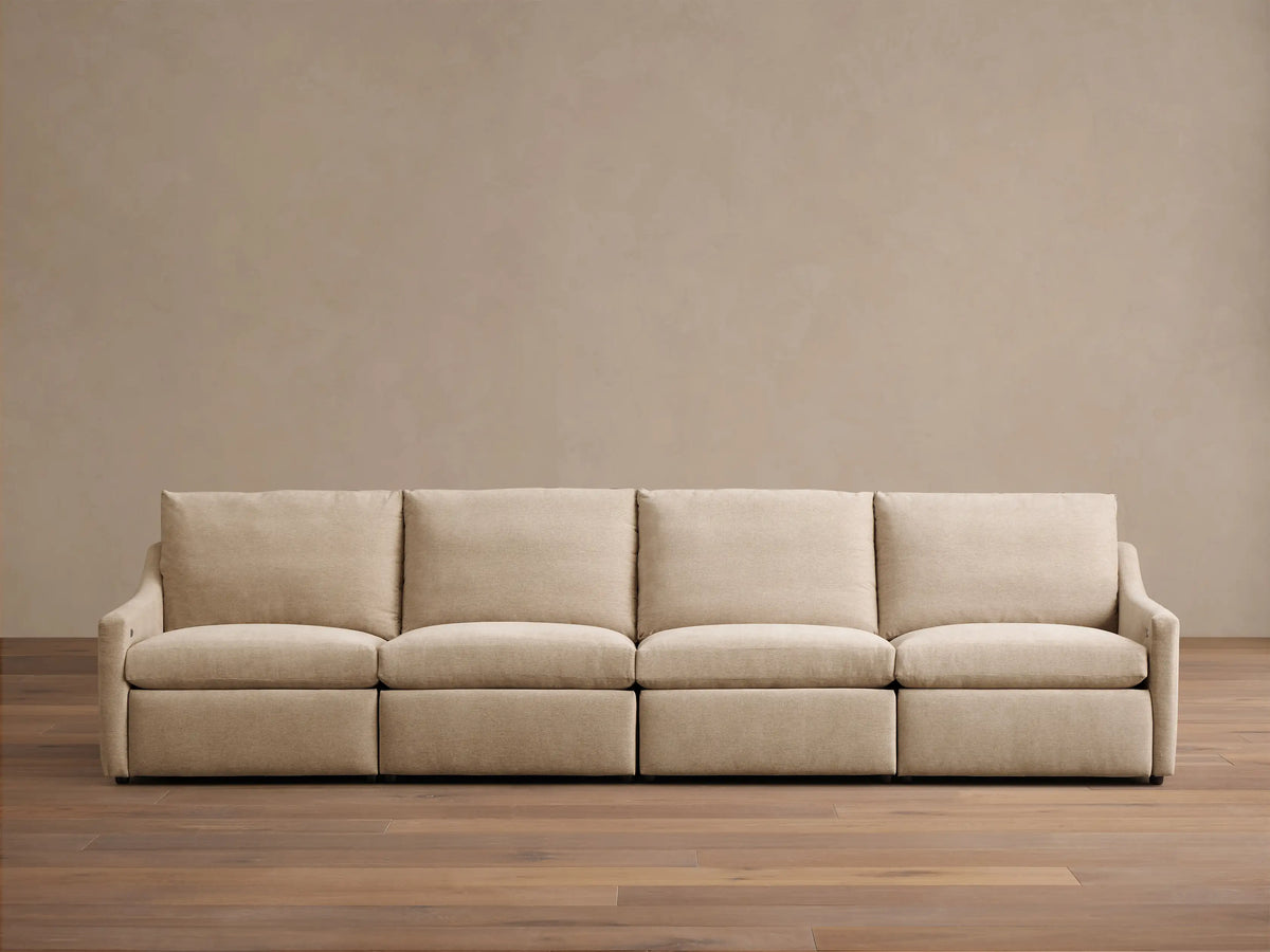 Front view of a beige Kipton Slope Arm Four-Piece Motion Modular Sofa with four seat cushions and sloped arms.