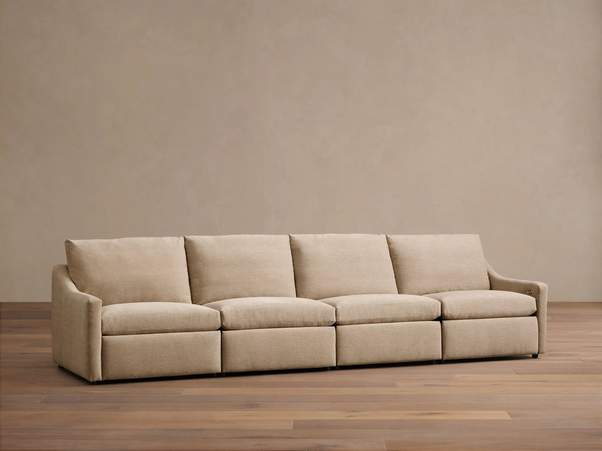 Front view of a beige Kipton Slope Arm Four-Piece Motion Modular Sofa with four seat cushions and sloped arms.
