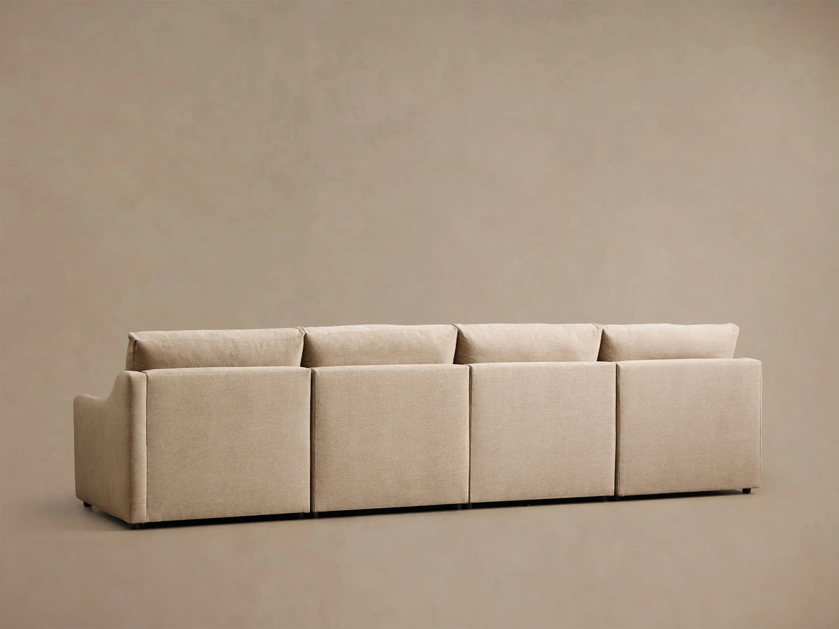 Close-up of a beige Kipton Slope Arm Four-Piece Motion Modular Sofa, showing a slope arm with a motion control button, modular sections, and an extended footrest.
