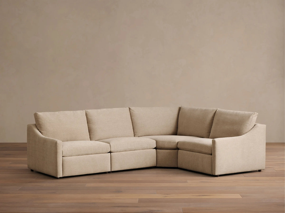 Front view of the beige Kipton Slope Arm Four-Piece Motion Sectional, configured in an L-shape with modular components.