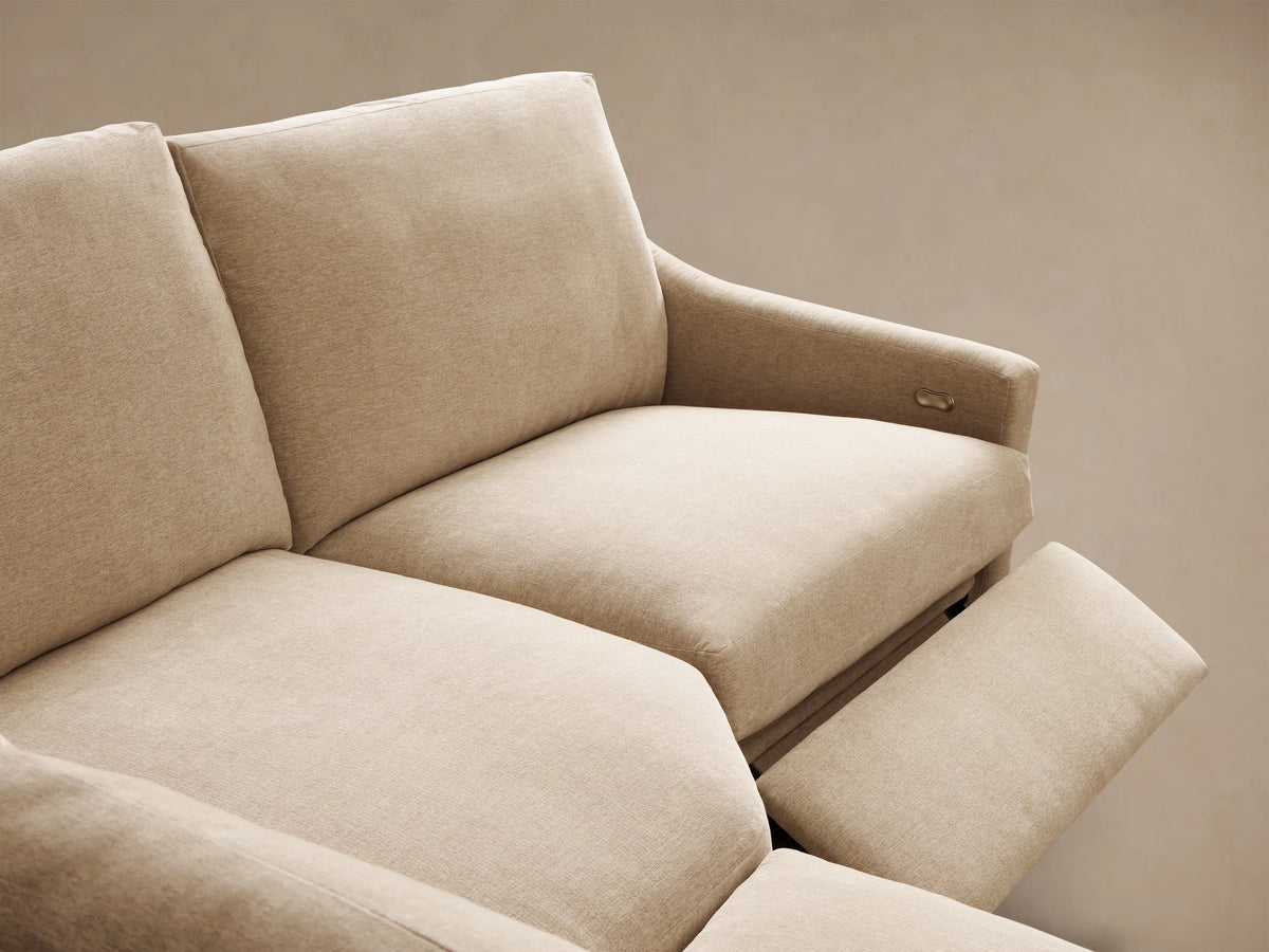 Front view of a light beige Kipton Slope Arm Four-Piece Motion Sectional, L-shaped with two seats extended for recline.