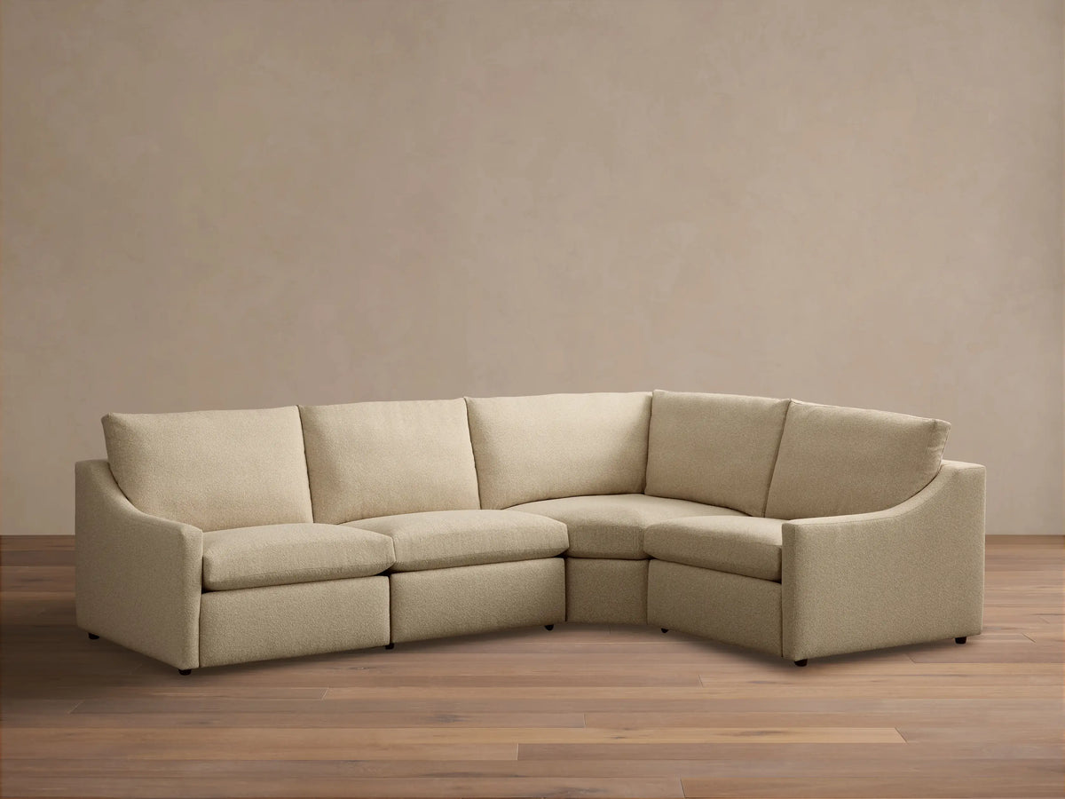Front view of the beige Kipton Slope Arm Four-Piece Motion Sectional, an L-shaped sofa with sloped arms.
