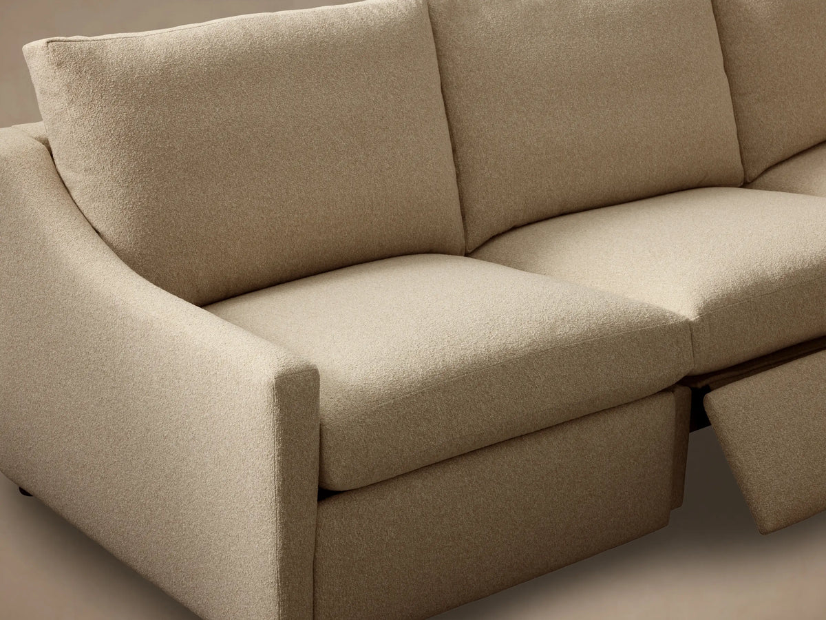 Close-up of the light beige textured Kipton Slope Arm Four-Piece Motion Sectional with a metallic motion control button.