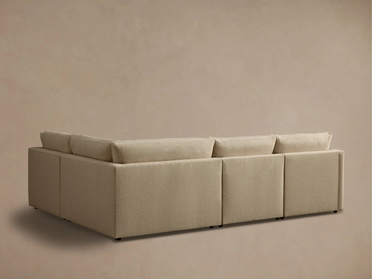 Front view of the beige Kipton Slope Arm Four-Piece Motion Sectional, showing the reclining footrest extended.