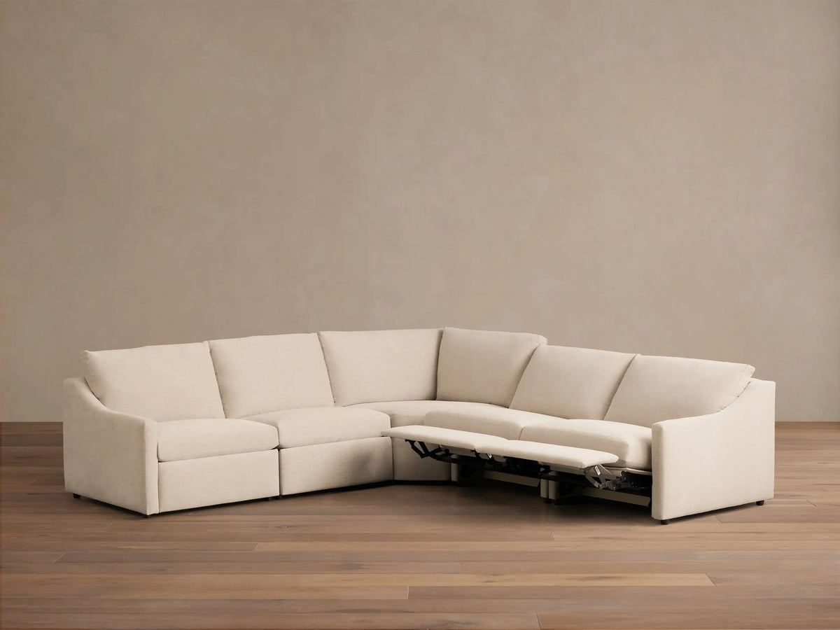 Front view of the cream Kipton Slope Arm Five-Piece Motion Corner Sectional with an extended recliner footrest.