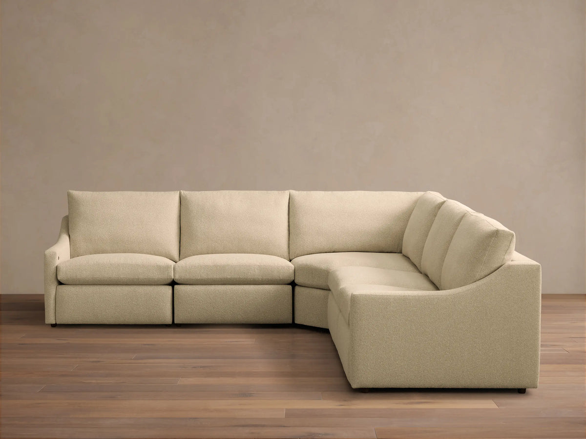 Front view of a Beige Kipton Slope Arm Five-Piece Motion Corner Sectional, showing its L-shape and textured fabric.