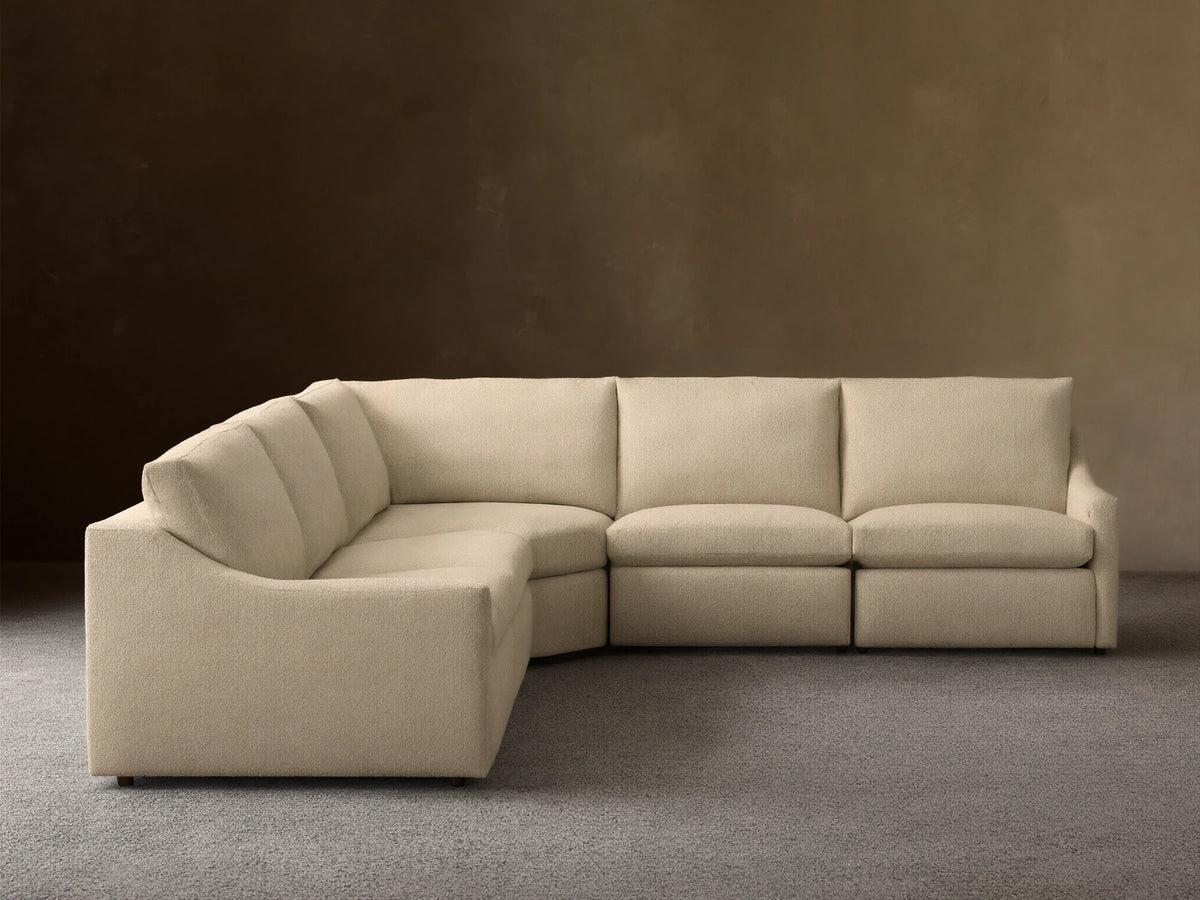 Front view of a Beige Kipton Slope Arm Five-Piece Motion Corner Sectional, showing its L-shape and textured fabric.
