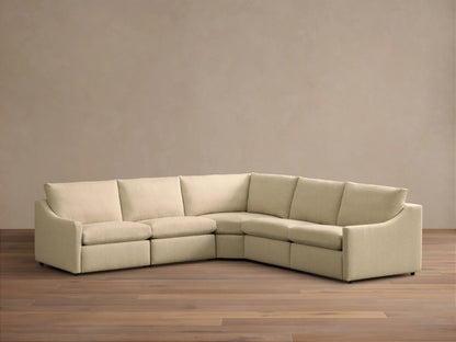 Front view of the cream Kipton Slope Arm Five-Piece Motion Corner Sectional™ with one seat reclined, extending a footrest.