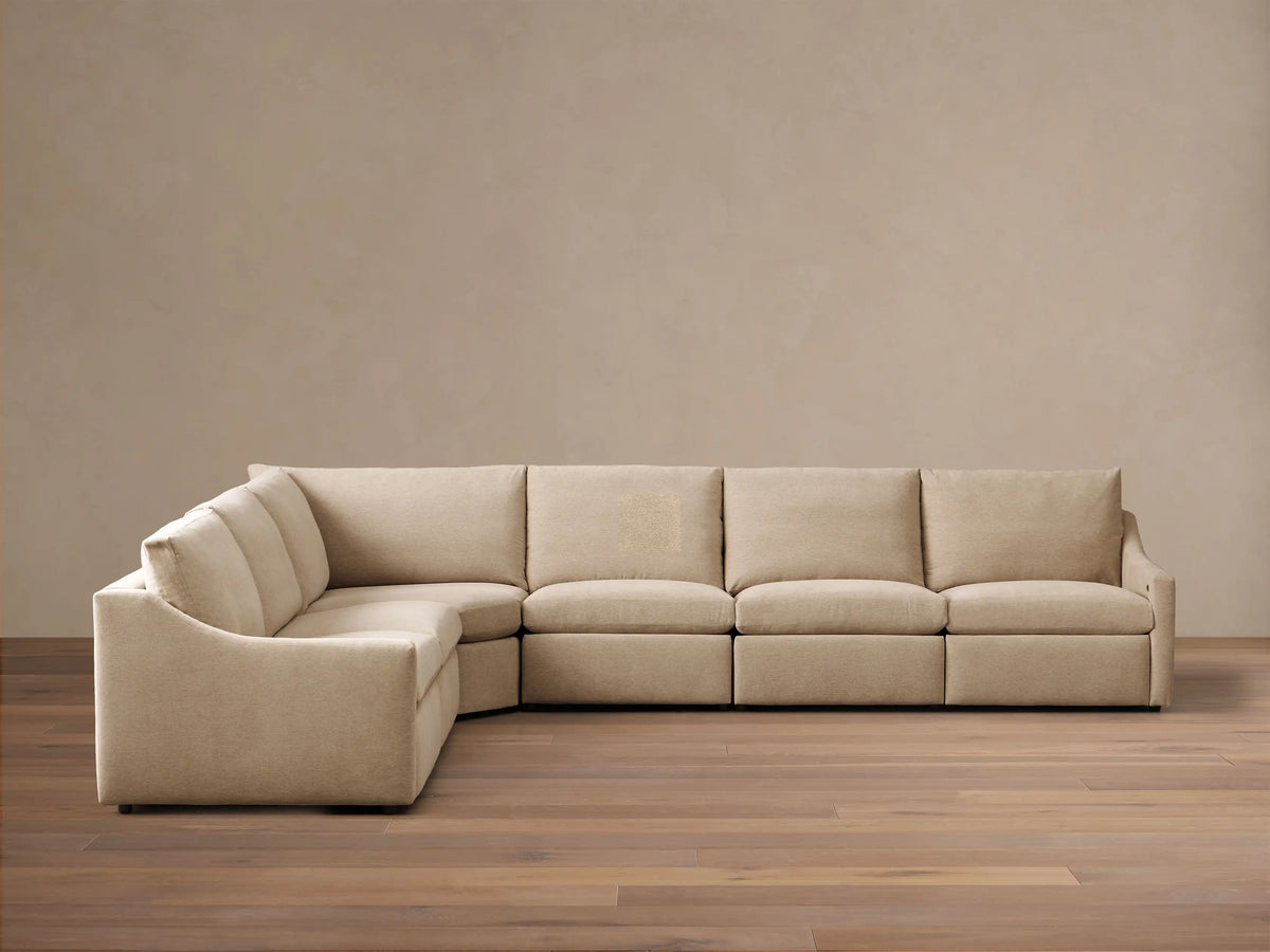 Front view of the light beige Kipton Slope Arm Six-Piece Motion Sectional. The L-shaped sofa has a sloped arm on the left.