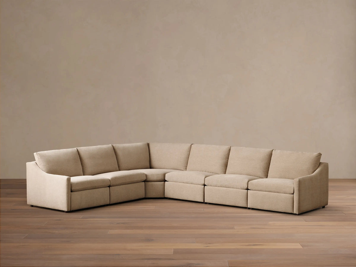 Front view of the light beige Kipton Slope Arm Six-Piece Motion Sectional. The L-shaped sofa has a sloped arm on the left.