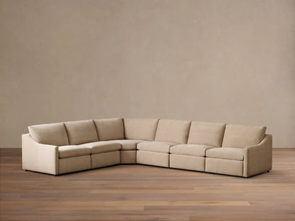 Front view of the light beige Kipton Slope Arm Six-Piece Motion Sectional. The L-shaped sofa has a sloped arm on the left.