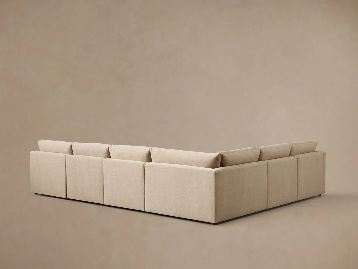 Close-up of a beige Kipton Slope Arm Six-Piece Motion Sectional with an extended footrest on the left.