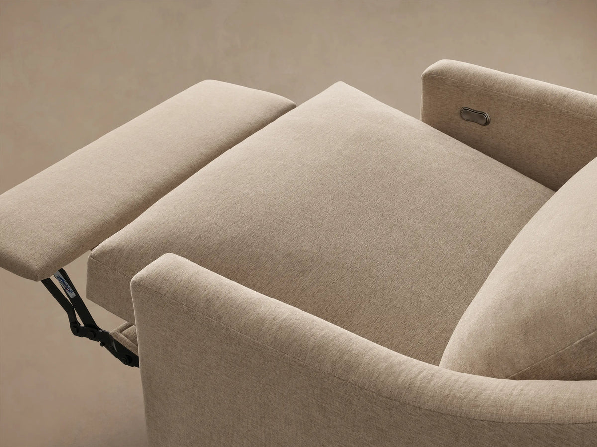 Close-up of the beige Kipton Slope Arm Motion Recliner's metallic oval control button.