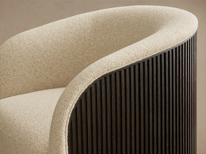 Close-up of the curved back and armrest of the Finnley Swivel Chair, featuring cream textured upholstery and a dark slatted wood exterior.