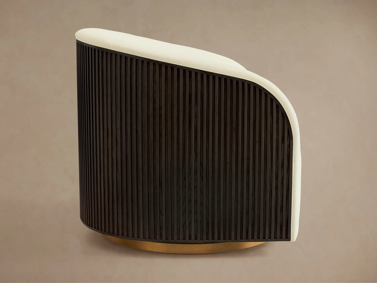 Finnley Swivel Chair with cream cushioned upholstery, curved backrest, and vertical slatted dark wood side panel.