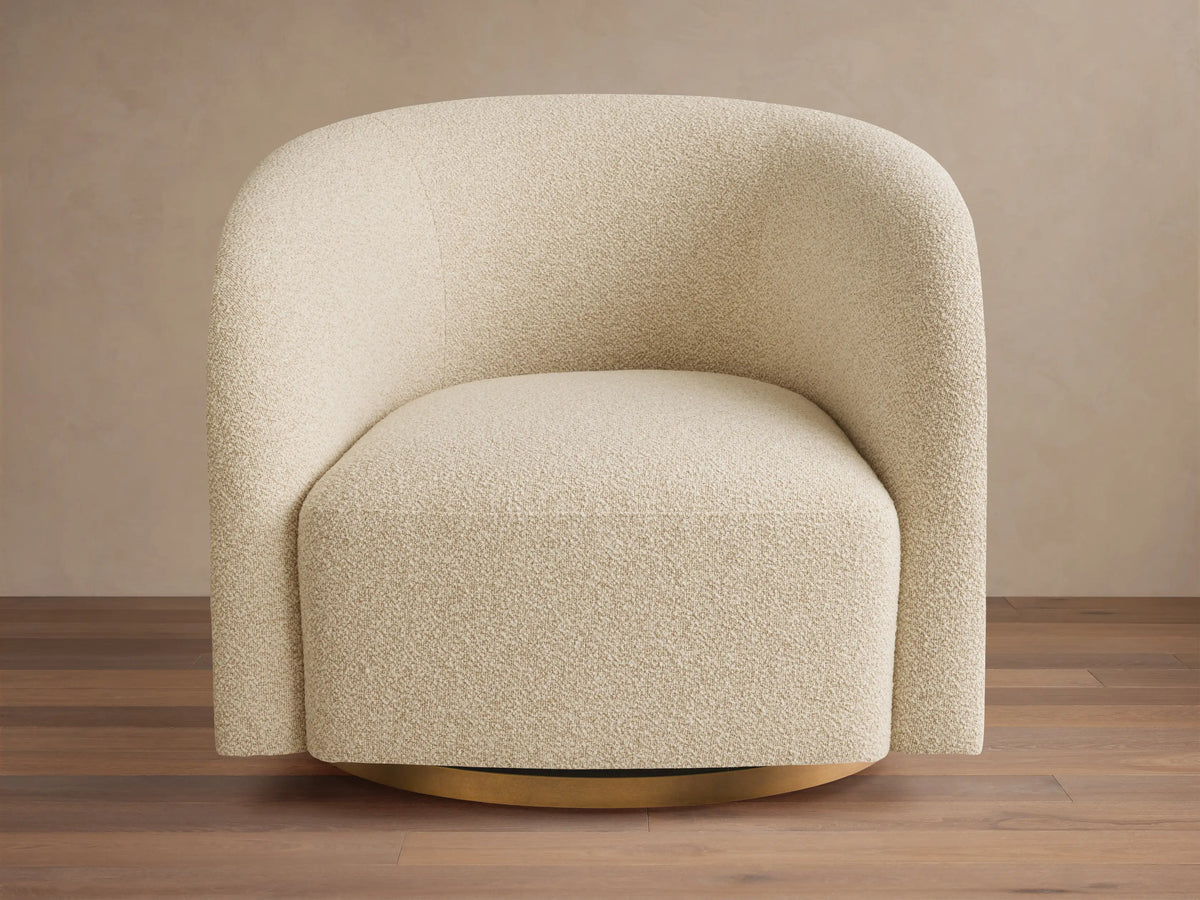 Front view of the cream bouclé Finnley Swivel Chair, featuring rounded arms and a visible gold swivel base.