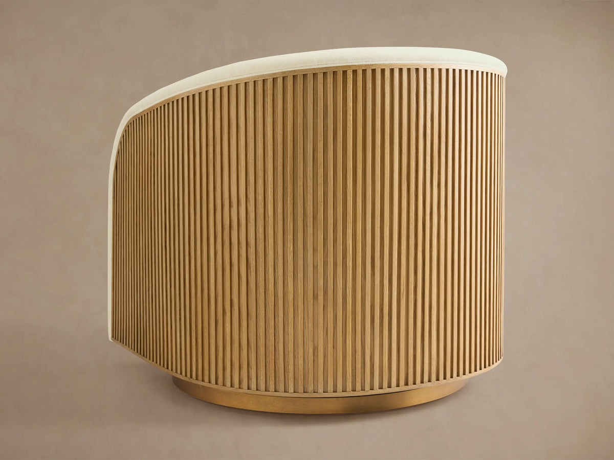 Finnley Swivel Chair with a curved back, featuring vertical slatted honey oak wood and a white cushioned seat, on a circular base.