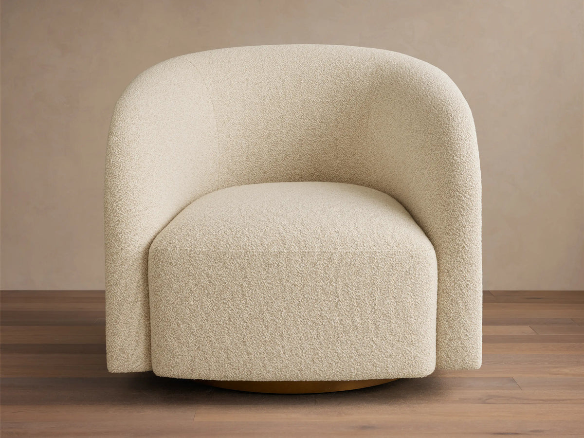 Front view of the cream Finnley Swivel Chair, featuring rounded arms and back, upholstered in a textured boucle fabric.