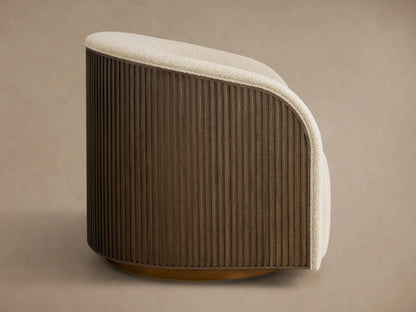 Side profile of the Finnley Swivel Chair, featuring cream textured upholstery and a dark brown fluted wood base on a bronze swivel.